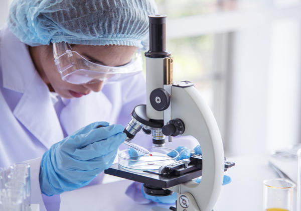 Female scientist looking through a microscope.