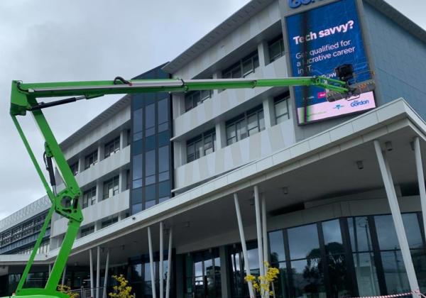 Commercial electricians repairing a digital advertising display in Geelong.